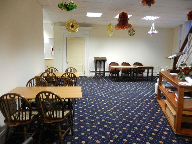 The bar area decorated for Christmas, with tables and wheelback chairs