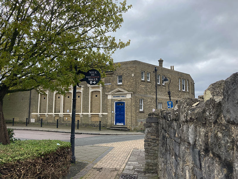 The Masonic Hall seen from beside the old town walls, with a Walk the Southampton Walls sign in the foreground