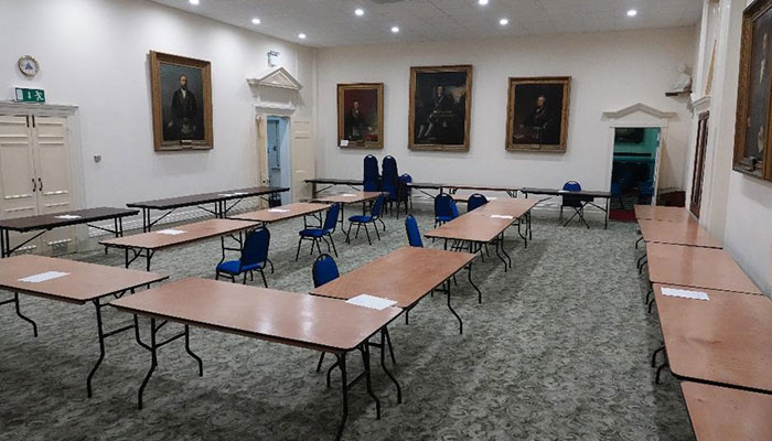 Tables arranged in small groups for a workshop in the Main Function Room