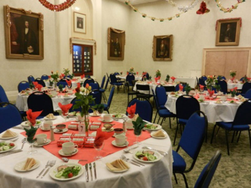 Round tables laid with white cloths and flowers in the Main Function Room